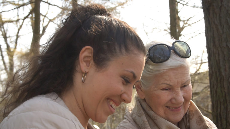 Nuori_ja_vanhempi_nainen_istuvat_lähekkäin