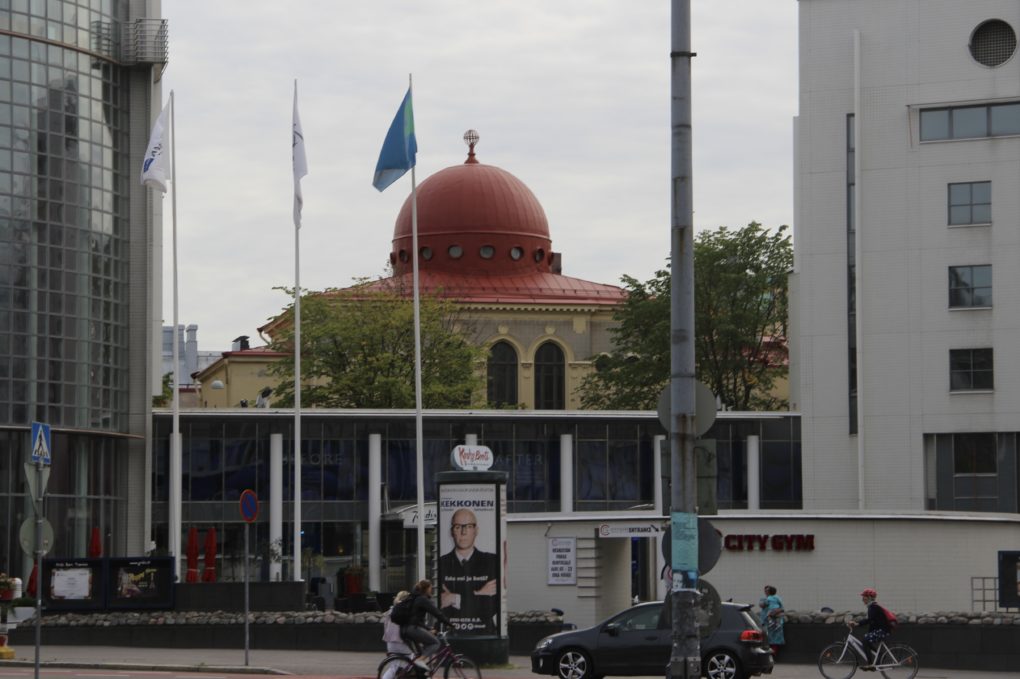 Helsingin juutalainen synagoga, jonka punainen katto näkyy kauempana ja edessä liehuu lippu