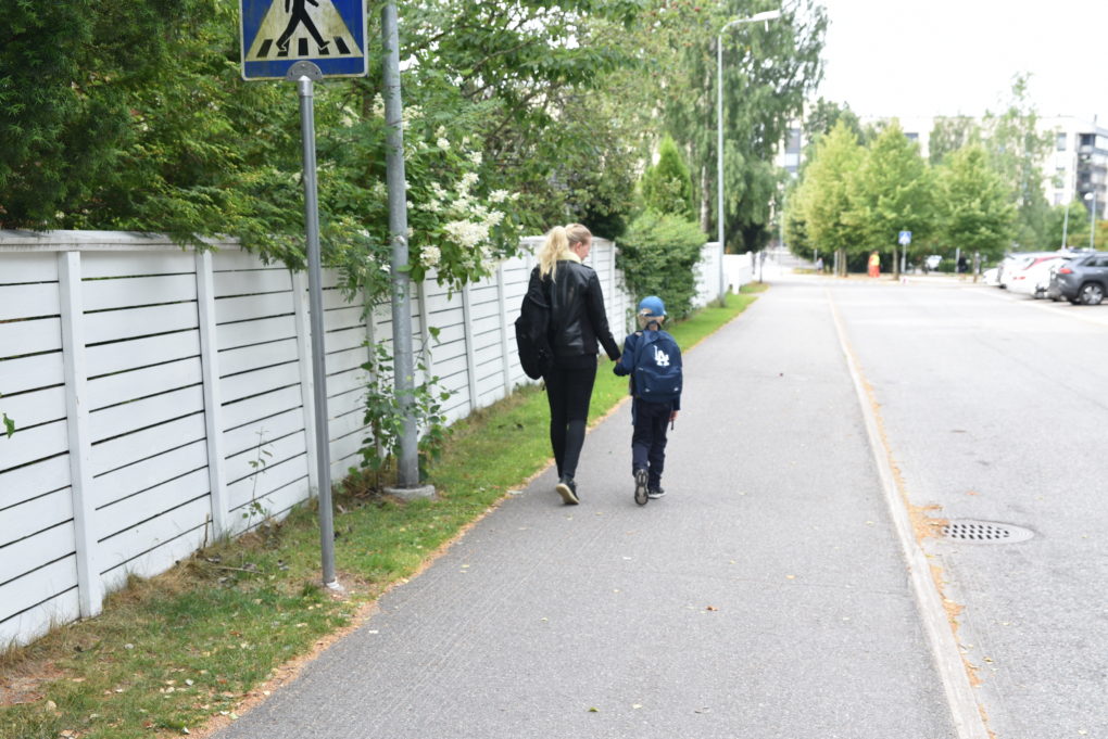 Ekaluokkalainen matkalla kouluun äitinsä kanssa.